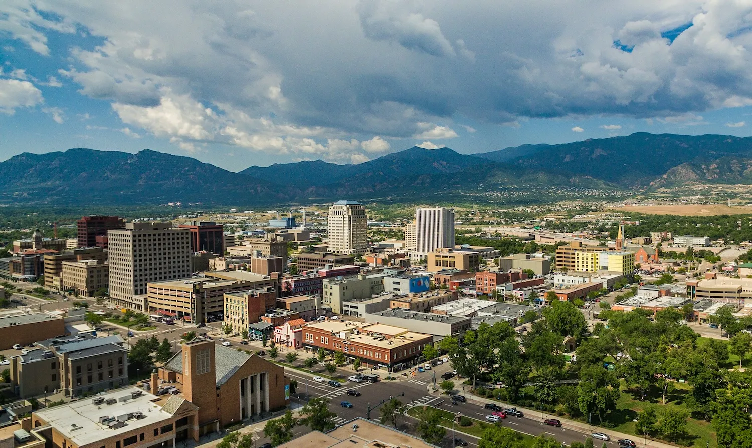 Downtown Colorado Springs with the Front Range mountains under summer clouds