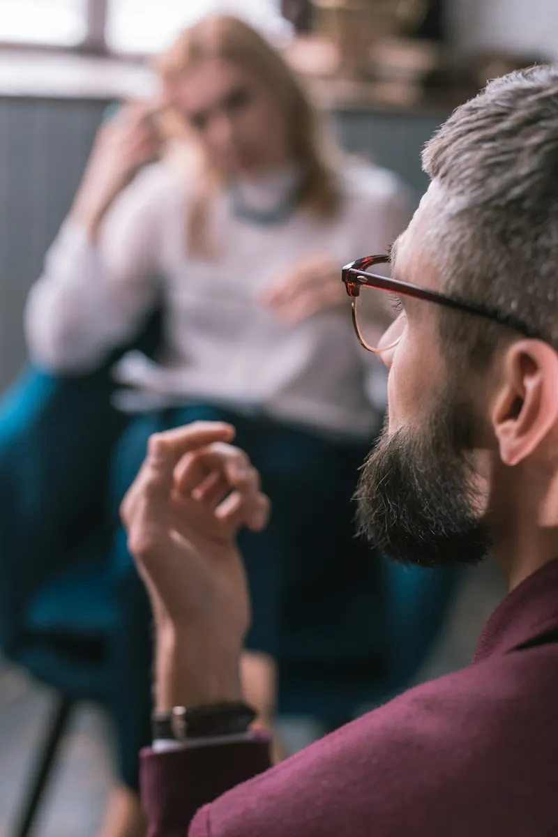 A man speaking to people in a room.