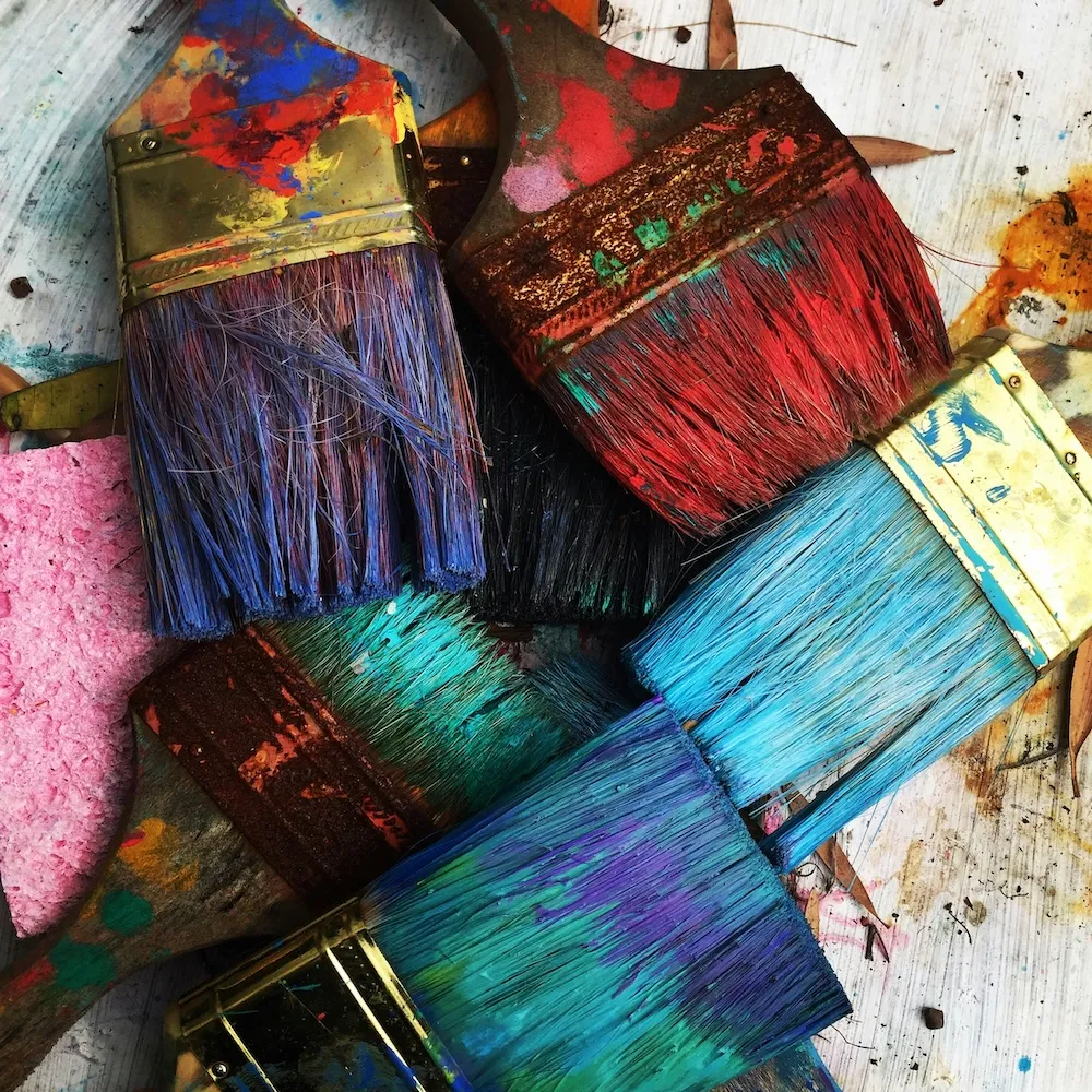 Paintbrushes with bright-colored paint on them.