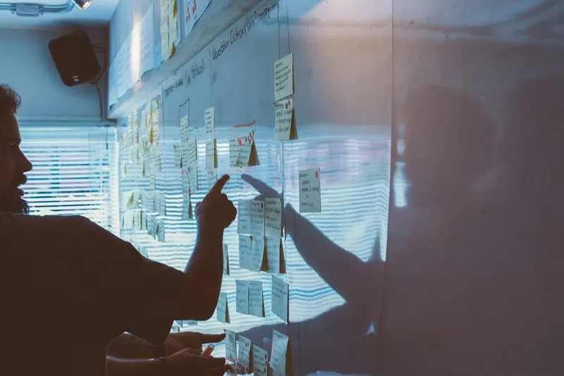 A team of designers working with sticky notes on a whiteboard.