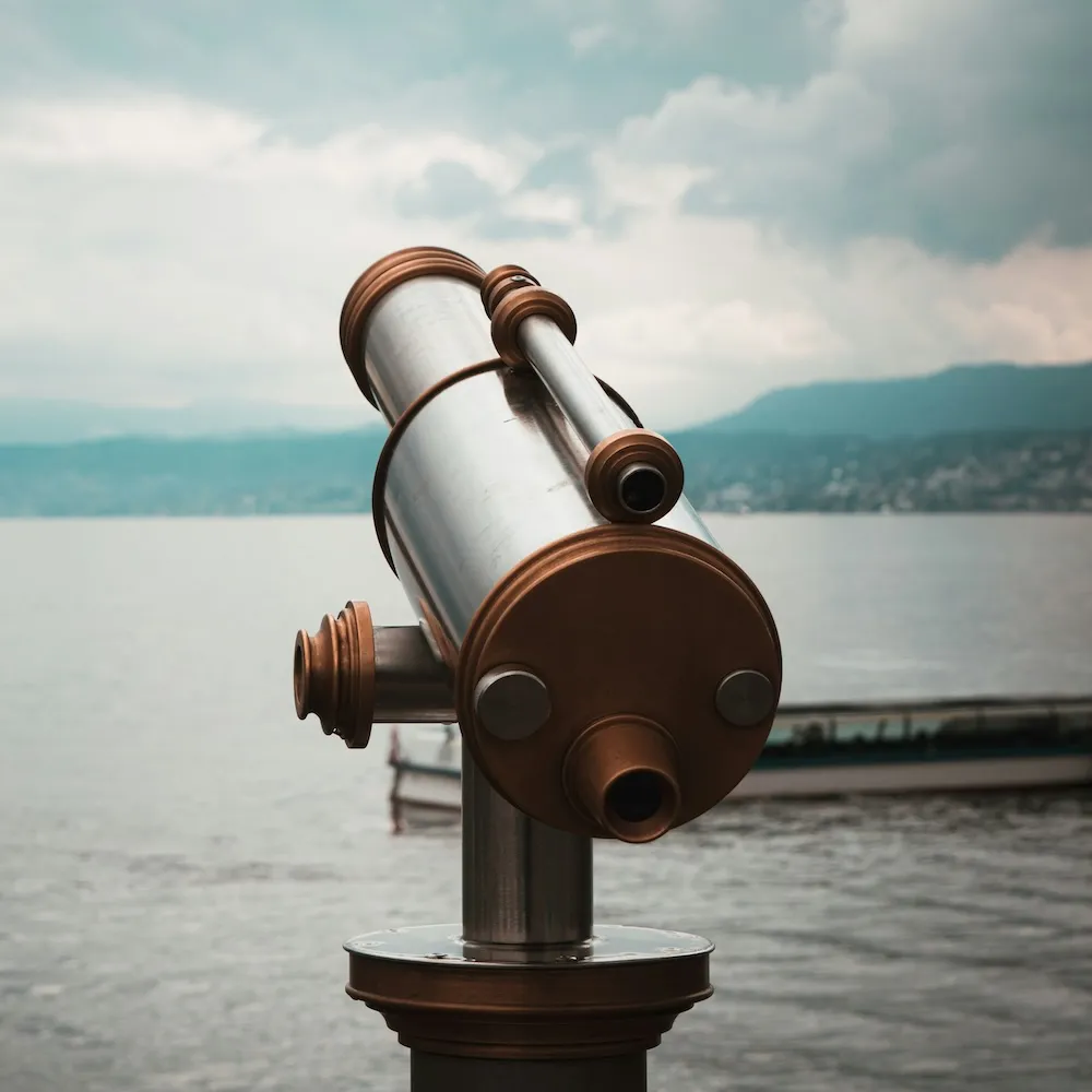 Photo of a telescope looking out over an ocean.